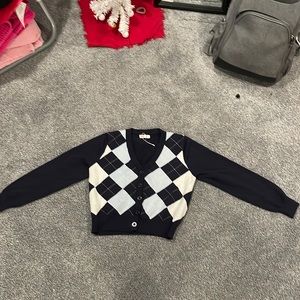 This a deep blue long sleeve button up cardigan with pattern on the front